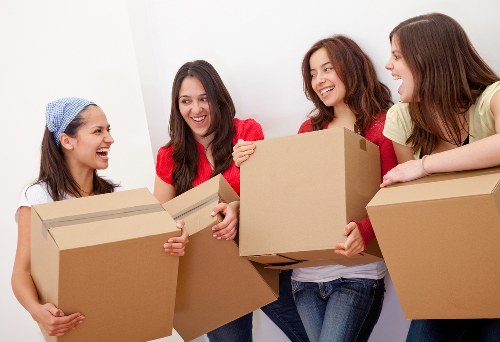 Professional movers carrying boxes in a Westminster apartment building