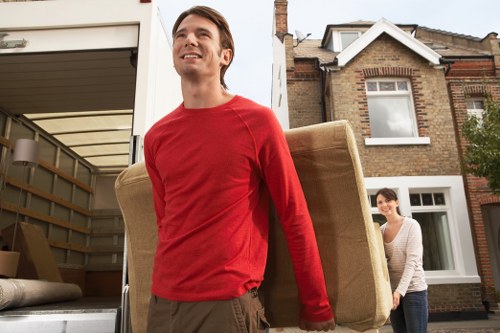 Trained removals crew using equipment to move heavy items safely